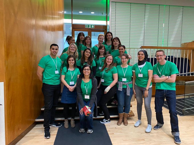 A team in matching green shirts together at an unconference event